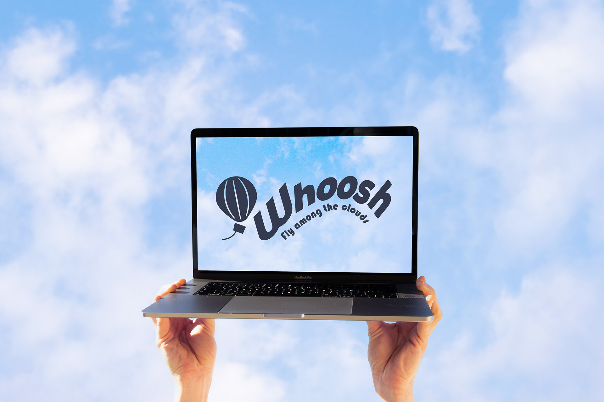 Hands holding up a laptop with Whoosh's website on screen.